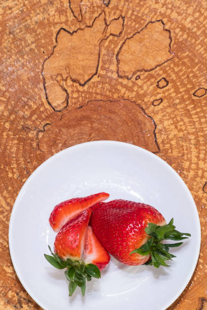 istock Red, ripe Strawberries on a white plate. Wooden background, flat lei. 1213068414