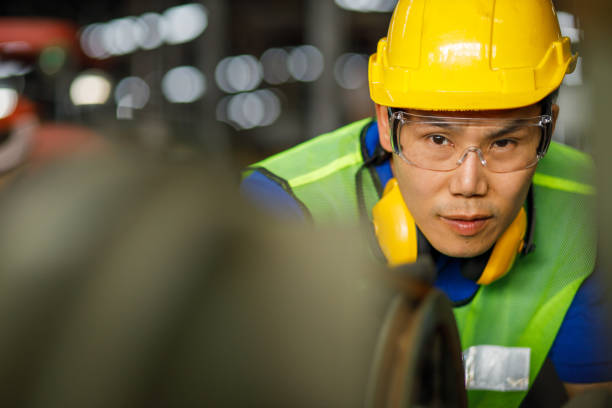 istock Professional asian worker engineer wearing a yellow helmet while standing in a heavy industrial he looking of working at industrial machinery and check security system setup in factory. 1213078481