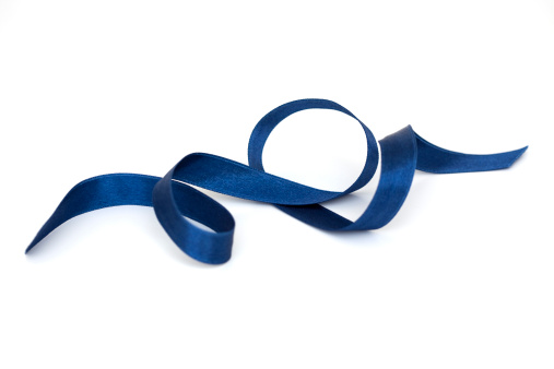 Shiny satin ribbon in blue color isolated on white background close up. Ribbon image for decoration design.