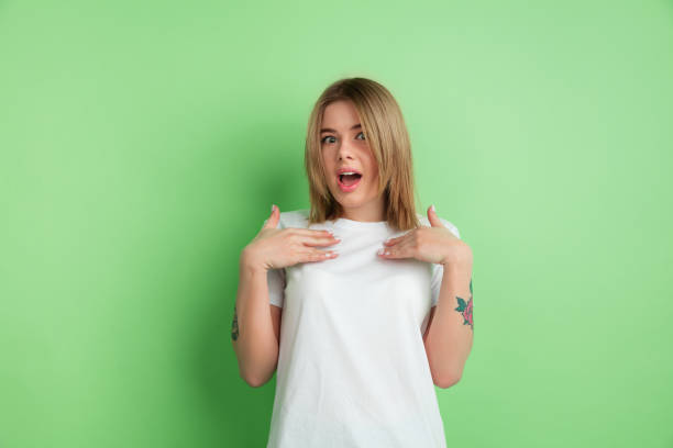 istock Caucasian young woman's portrait on green studio background 1213084329