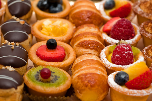 yummy assortment baked pastry in bakery. Various Different Types Of Sweet Cakes In Pastry Shop Glass Display. Good Assortment Of Confectionery. buffet with many desserts.