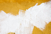 A yellow wall splashed with white paint