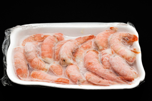 close-up of frozen shrimps vacuum packed on black background