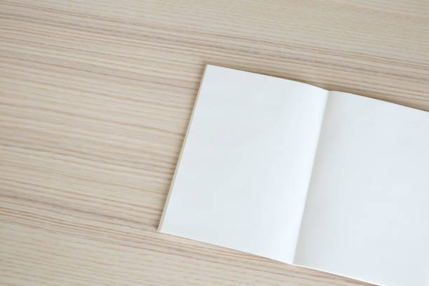 istock Mock up blank open paper book on wood table background 1213087170