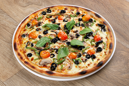 veggie pizza with vegetables on a wooden background