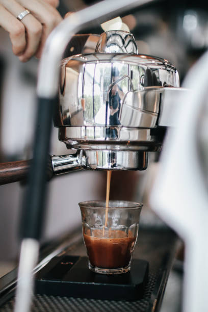 istock Coffee machine with steam in the process a cafe.Barista Cafe Making Coffee Preparation Service Concept.Barista is pouring coffee in a measure milk glass at the cafe. Close up, selective focus, toned, space for text. 1213098068