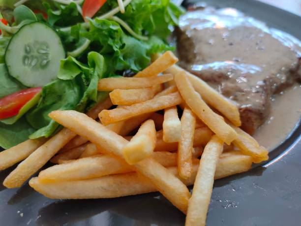 istock Selected focus on french fried with Steak ,salad on black disk 1213098397