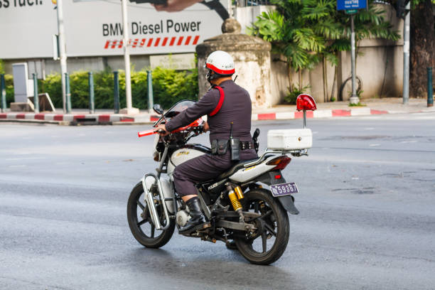 Bangkok, Thailand - September 20th 2009: A policeman rides his motorcycle down a street. This is their preferred method of transport.