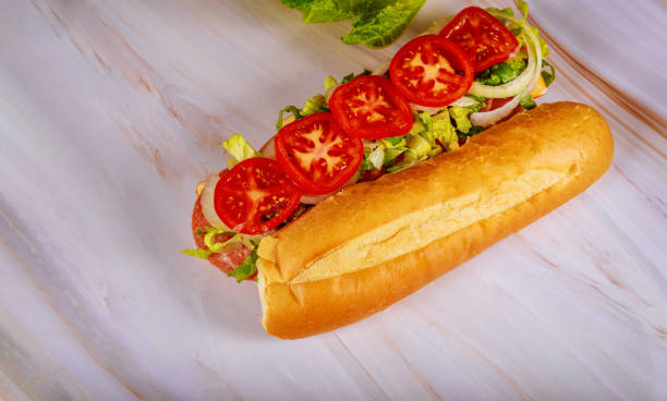 sándwich con pan francés, queso muenster, salami y verduras. - sandwich submarine delicatessen salami fotografías e imágenes de stock