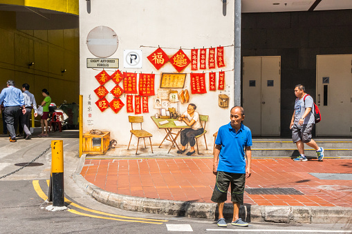 Singapore - July 5th 2019: Man waiting to cross the road on Smith street. This is one of the main streets in the area.