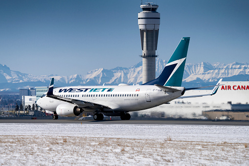 A Westjet Boeing 737 lands at Calgary International Airport (CYYC). Westjet is dealing with reduced scheduled flights due to the COVID-19 outbreak.