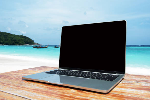 istock Mobile work office on the beach with blank laptop screen 1213120088
