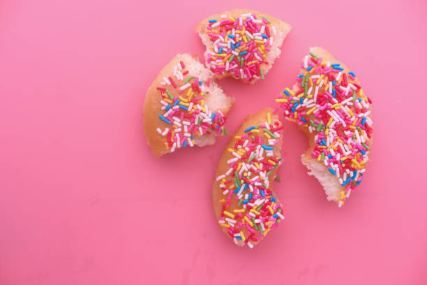 istock Donut shape made of cut donut slices on pink background 1213125452