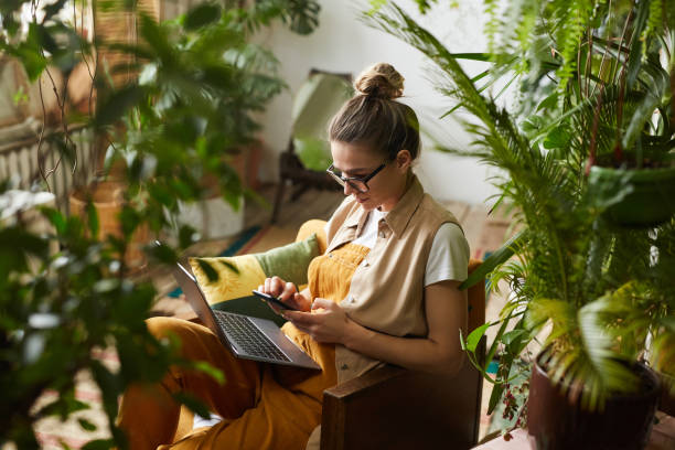 флорист, работающий на ноутбуке - relaxation indoors reading one person стоковые фото и изображения