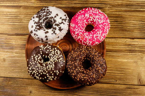 istock Tasty donuts on a wooden table. Top view 1213129699