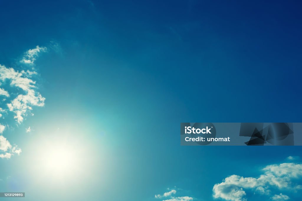 The sun shines bright in summer. Blue sky and clouds. The sun shines bright in summer. Blue sky and clouds.- image toned Backgrounds Stock Photo