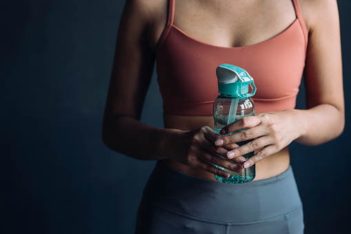 Close up shot of a sportswoman's hands holding a water bottle.