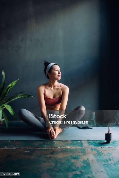 Asiatische Frau Sitzt Auf Einer Übungsmatte Und Wärmt Sich Für Eine Yogasession Auf Stockfoto und mehr Bilder von Yoga