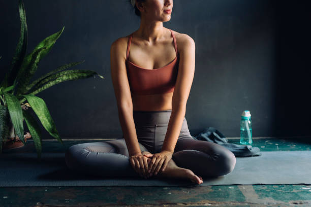 istock Before Yoga: Asian Woman Sitting on an Exercise Mat 1213135392