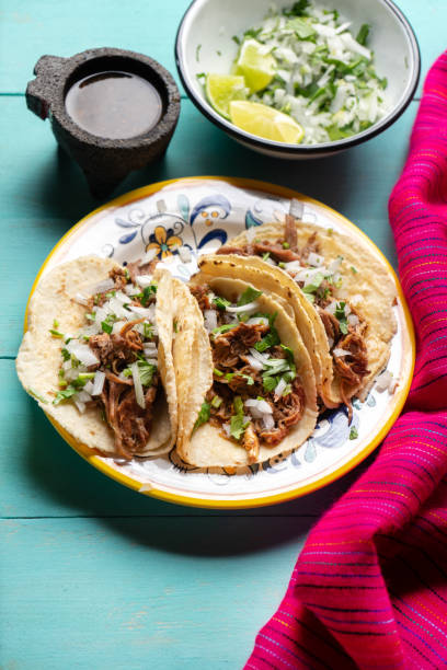 istock Mexican slow cooked lamb tacos also called barbacoa on turquoise background 1213136881