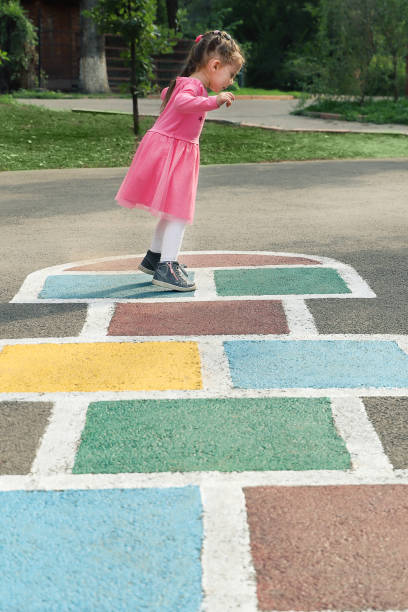 istock Young cute girl playing hopscotch on backyard 1213140502
