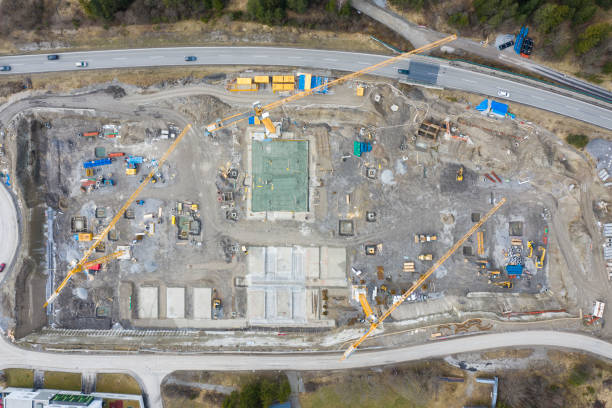 istock drone aerial view to huge building construction site with digger crane and bulldozer 1213141500