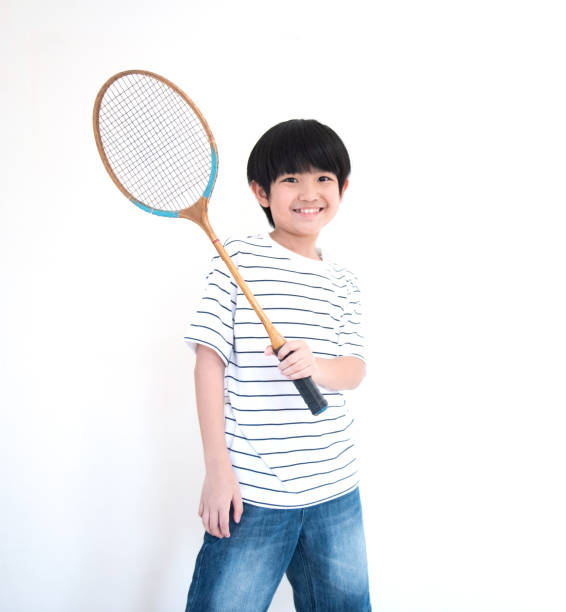 istock little asian school boy with racket isolated on white background. 1213142074