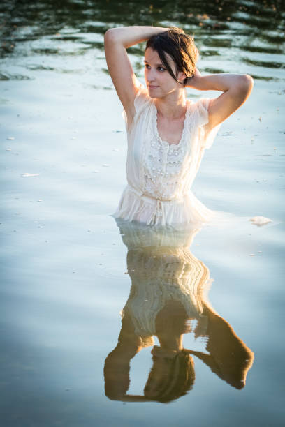 istock Woman standing halfway in the lake 1213143882