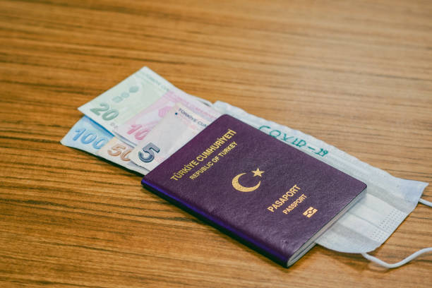 istock Turkish pasaport and Turkish Lira and a green surgical face mask. Concept about COVID-19 transmits via money. 1213144708