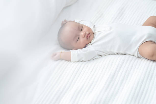 petit bébé asiatique faisant la sieste dans le bâti à la maison. - baby yawning asian ethnicity newborn photos et images de collection