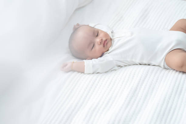 bebê asiático cochilando na cama em casa. - newborn little girls baby lying down - fotografias e filmes do acervo