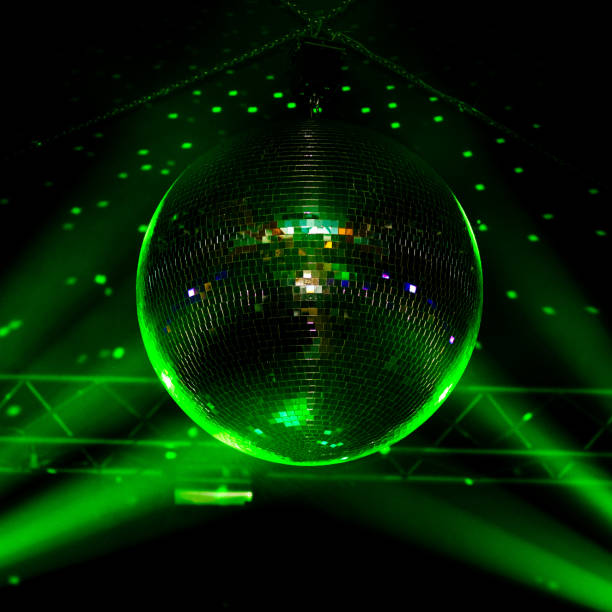 istock Closeup green light disco ball with dots on wall and rays, night club background. 1213145276