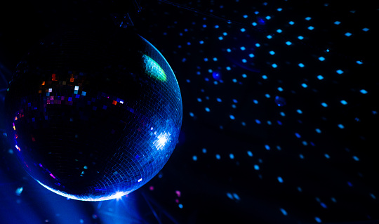 Blue light disco ball with dots on wall, night club background
