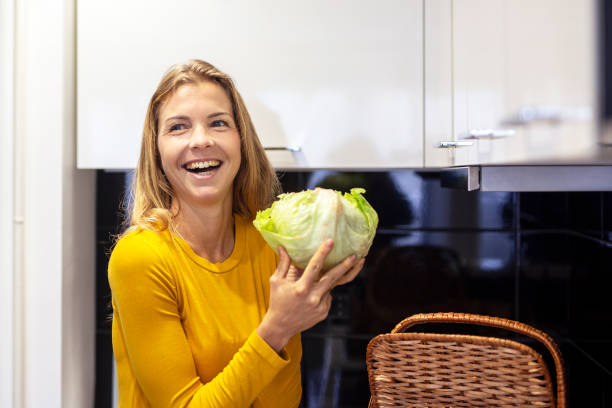 istock Woman with cabbage on her hand in kitchen 1213148660