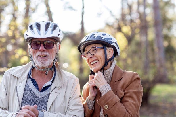 istock Senior couple with bycicles and helmets in park 1213148669