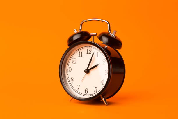 time background concept. vintage classic alarm clock on orange empty background. time management comcept - clock time alarm clock orange imagens e fotografias de stock