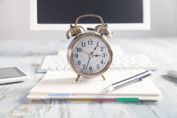 istock Alarm clock with business object on the desk. 1213150143
