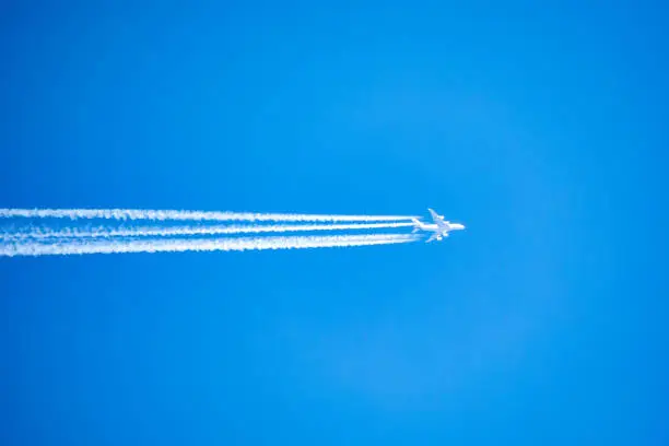 Photo of long trail of jet plane on blue sky