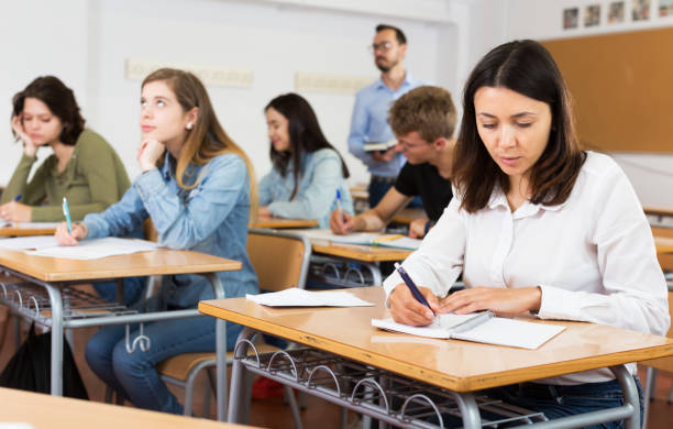 istock Girl writing test in classroom 1213152091