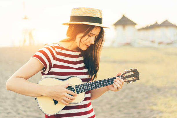 istock young woman ukulele sunset 1213152272