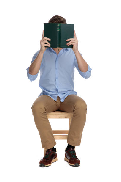 istock Young casual man covering his face with a book 1213152530