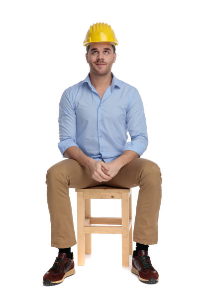 istock Funny casual man looking up guilty, wearing hard hat 1213153515