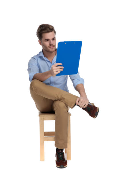 istock Focused casual man reading clipboard while sitting 1213153778
