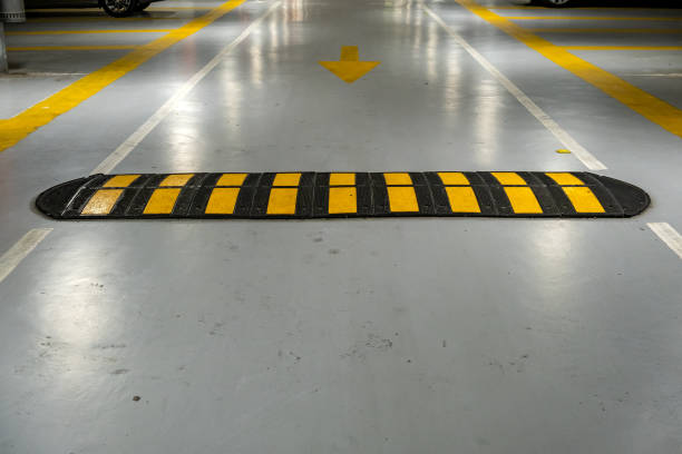 istock Striped black and yellow speed bump on a road. 1213153784