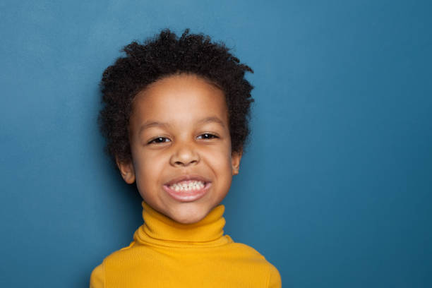 istock Mischievous black child boy on blue background 1213154204