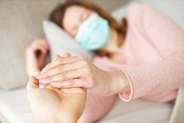 una giovane donna giace malata sul divano nel soggiorno - cold and flu flu virus bed couple foto e immagini stock