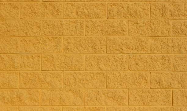 mur de bloc peint jaune de cendre. fond et texture, gros plan - cinder block photos et images de collection