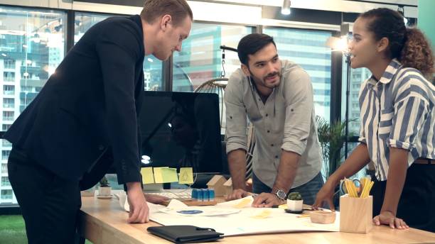 Creative business people group having conversation at office desk in workplace.