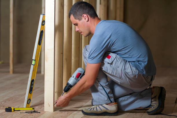 istock Young professional worker uses level and screwdriver installing wooden frame for future walls. Interior of attic insulated room with oak floor under reconstruction.  Renovation and improvement concept. 1213161844