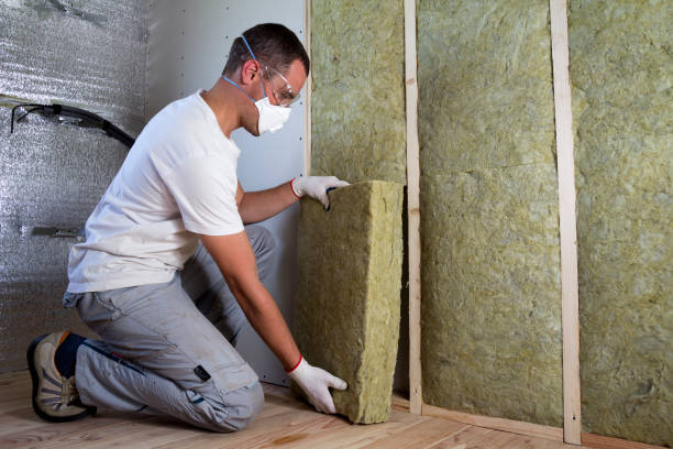 istock Worker in protective goggles and respirator insulating rock wool insulation in wooden frame for future house walls for cold barrier. Comfortable warm home, economy, construction and renovation concept 1213161858